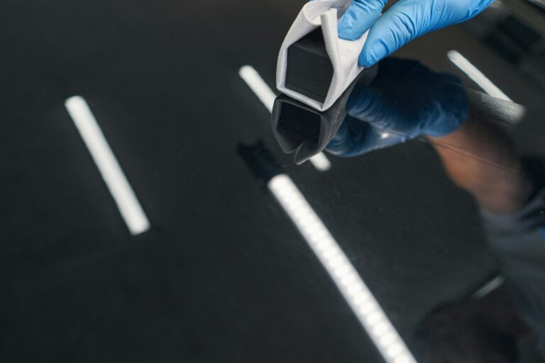 man-car-detailing-studio-worker-applying-ceramic-coating-on-car