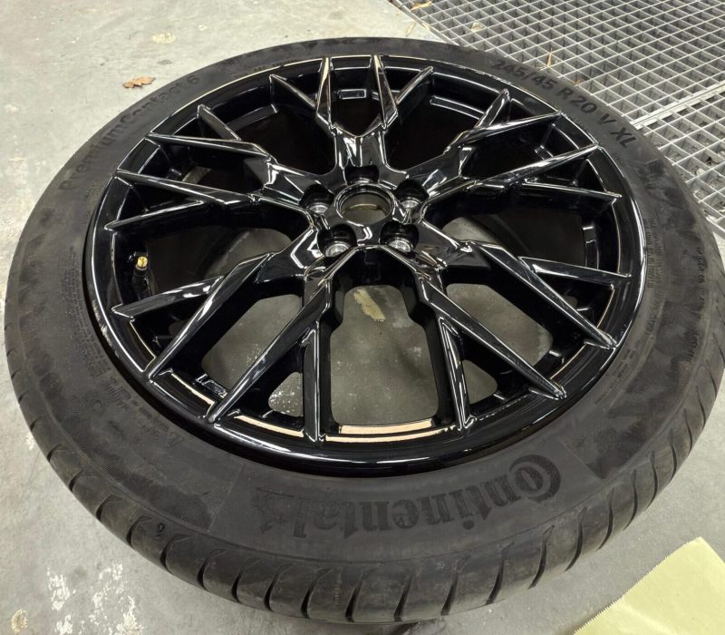 Zwart gespoten velg in afwerkingsfase na renovatie of lakbehandeling.
